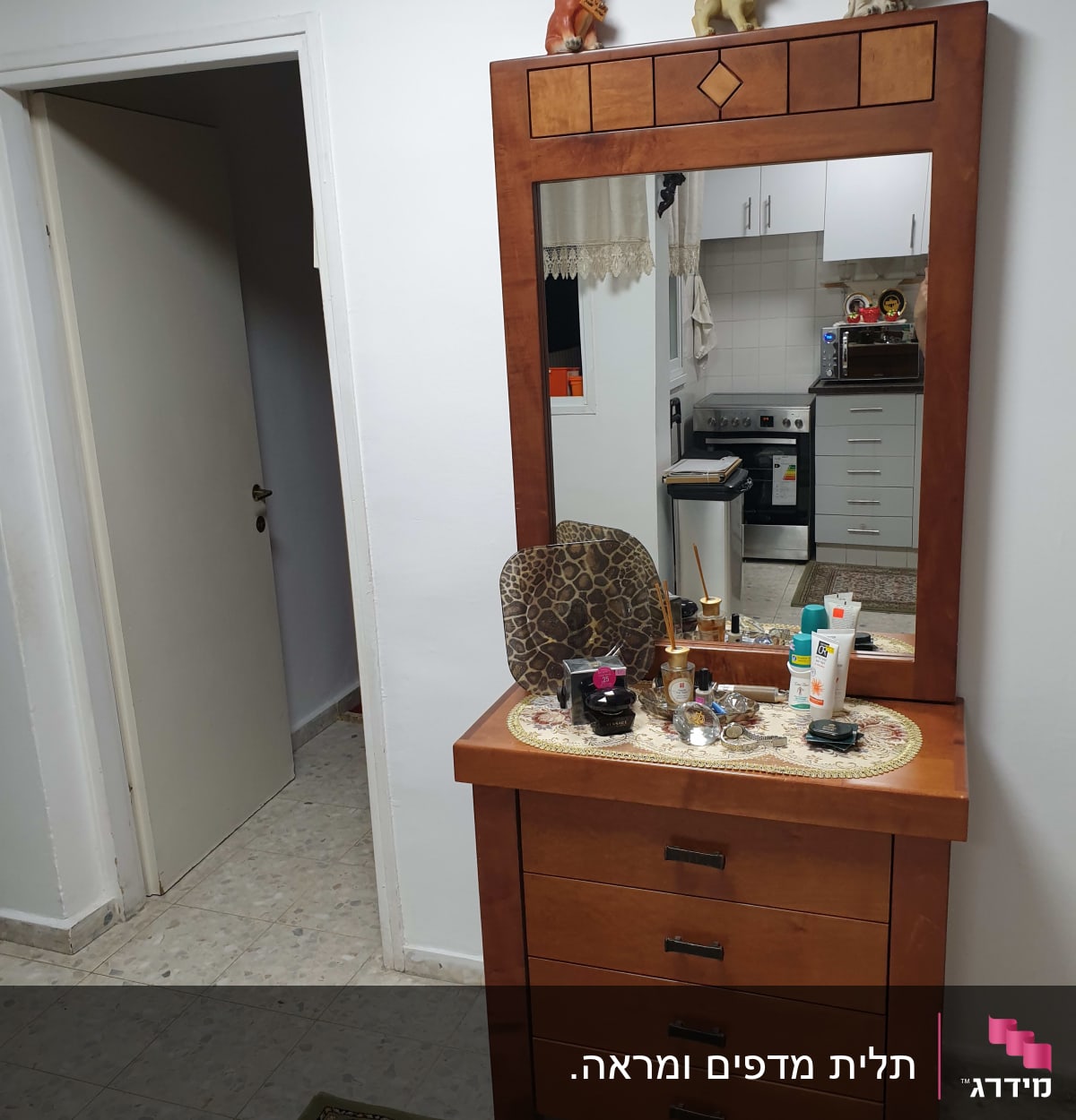 שידה עם מראה וכלי טיפוח על השידה